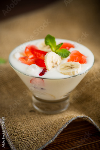 homemade sweet yogurt with bananas and pieces of fruit jelly