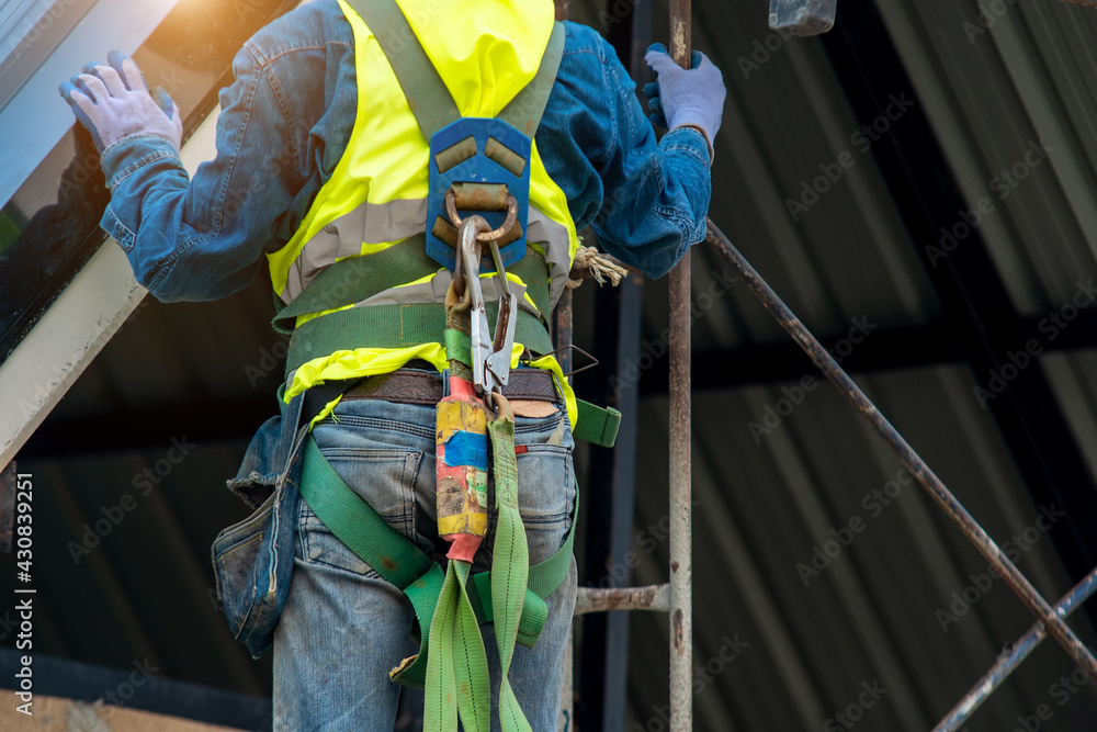 Construction worker wearing safety harness belt during working at high place,New House Construction,Roofing Job.