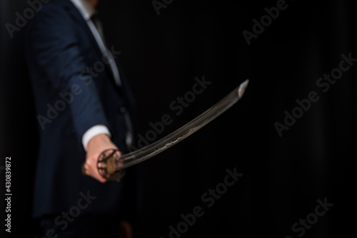 スーツを着て日本刀を構える男性