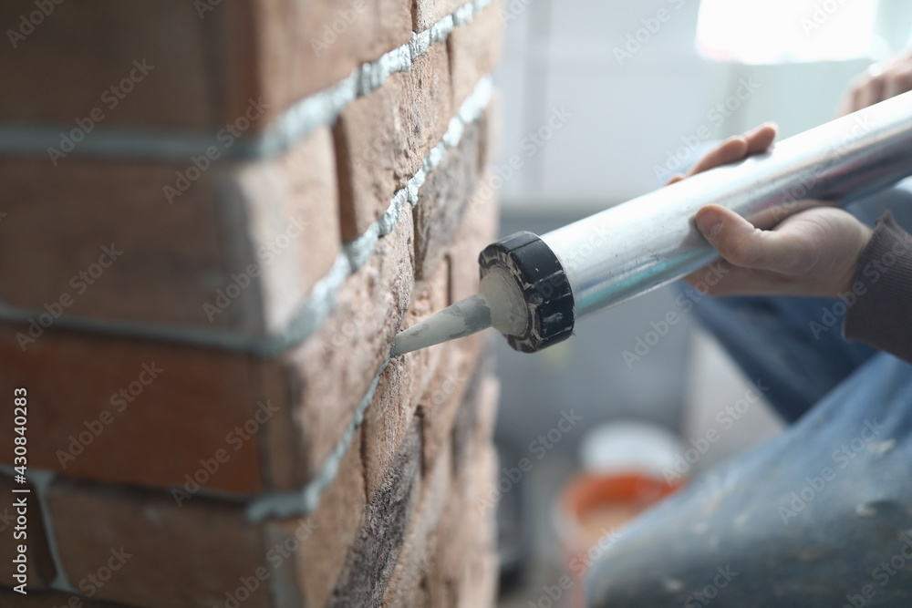 Master builder pours puffer into brickwork with special pisto Master builder pours puffer into brickwork with special pisto