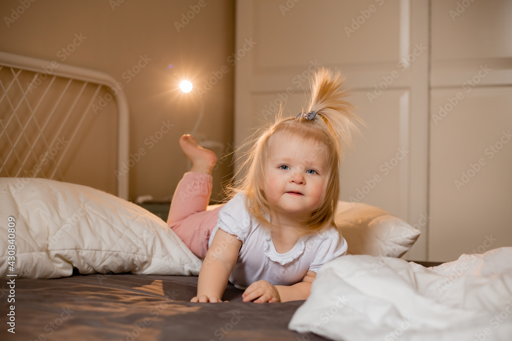 Fototapeta premium Happy little girl pragy in bed at home