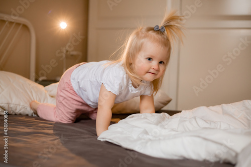 Happy little girl pragy in bed at home