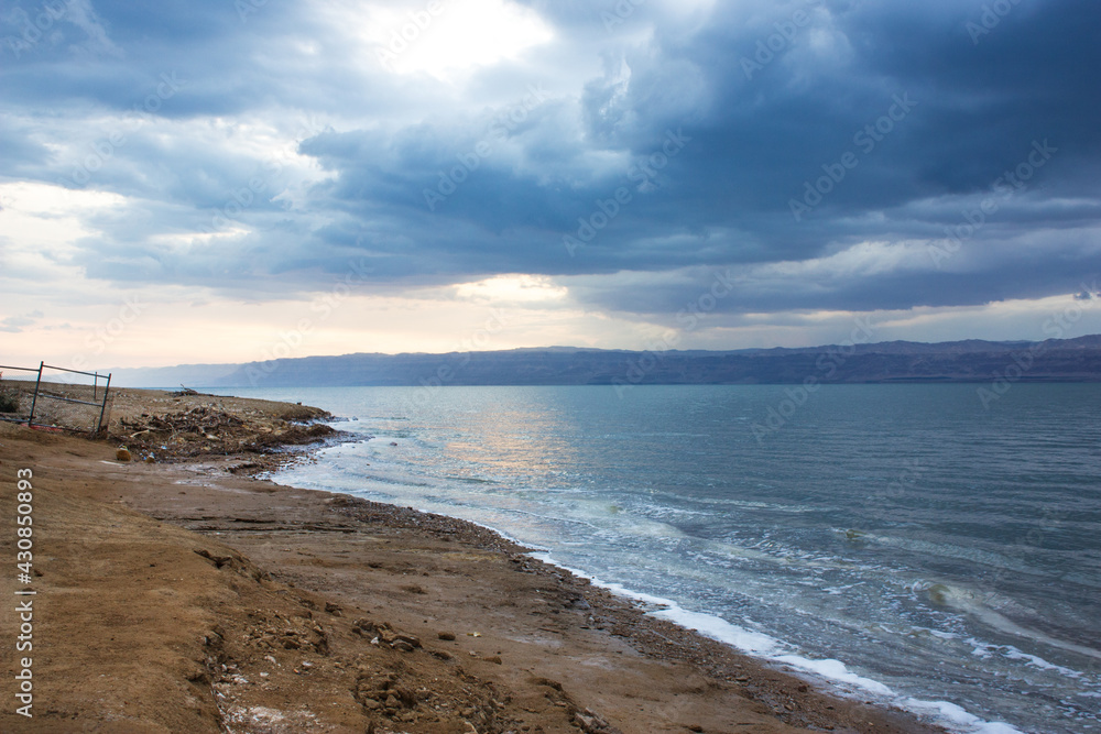 Deserted shore of Dead sea on Jordanian side in off-season, view of Israel, beach is closed during coronavirus infection, COVID-19.
