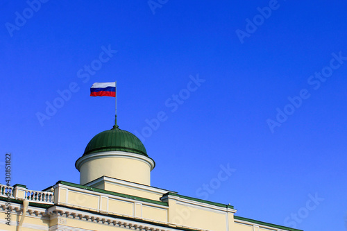 Russian flag on the roof of the building. clear blue sky.