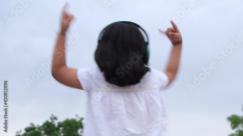 Little girl listening music. Shoot from back side.