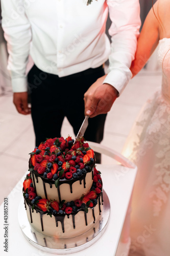 Wedding cake decorated with fresh strawberries.