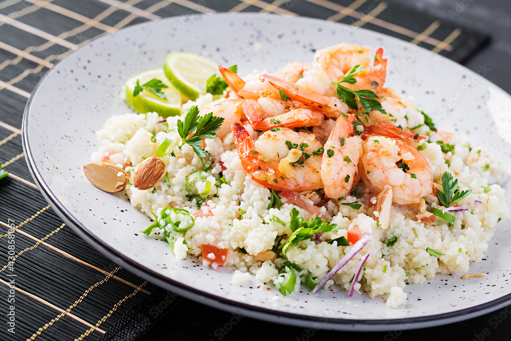 Couscous with roasted shrimps, tomatoes, red onions, almond nuts and parsley. Moroccan food with couscous and prawns. Couscous with roasted shrimps, tomatoes, red onions, almond nuts and parsley. Moroccan food with couscous and prawns.