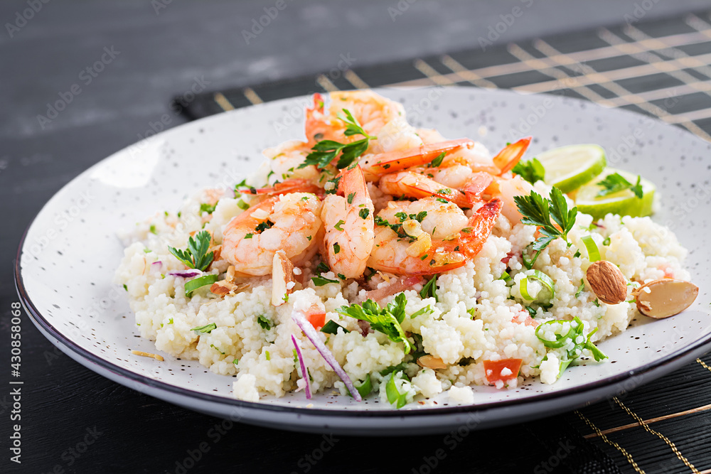 Couscous with roasted shrimps, tomatoes, red onions, almond nuts and parsley. Moroccan food with couscous and prawns. Couscous with roasted shrimps, tomatoes, red onions, almond nuts and parsley. Moroccan food with couscous and prawns.