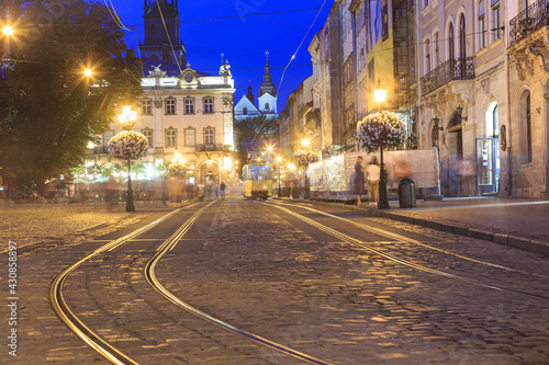 A street in the center of the old city with a streetcar at night