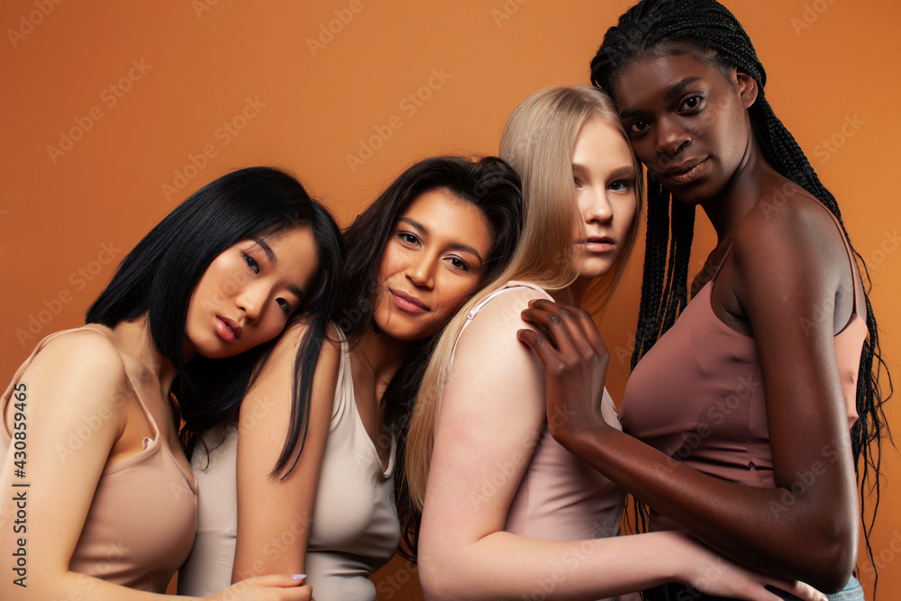 Obraz premium young pretty asian, caucasian, afro woman posing cheerful together on brown background, lifestyle diverse nationality people concept