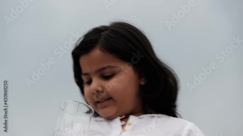Little girl drinking juice in a glass
