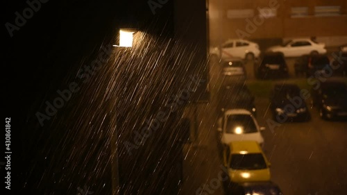 Heavy rain falls in the closed night over a city