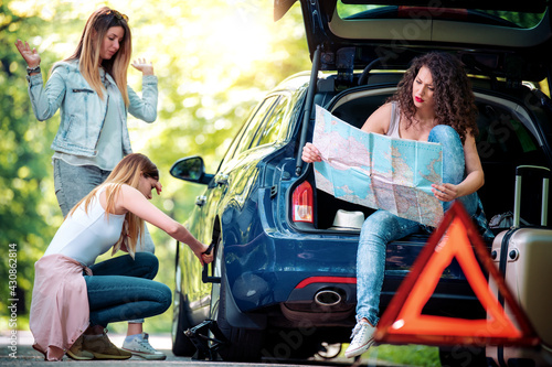 Girls with a broken car on the road