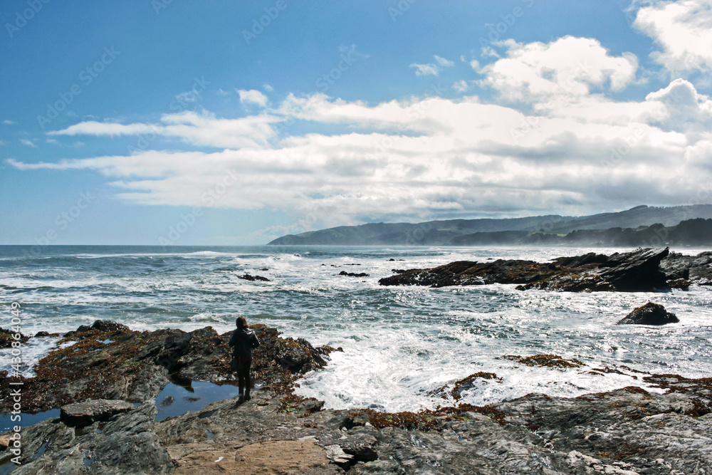 person standing on a rock closer to the sea person standing on a rock closer to the sea