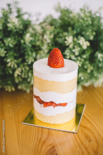 Strawberry shortcakes with whipped cream and fresh berries on wooden table
