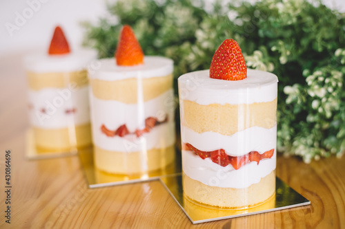 Strawberry shortcakes with whipped cream and fresh berries on wooden table