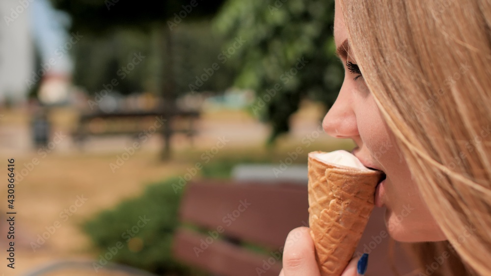 The girl eats an ice cream cone on the street of the city. The girl eats an ice cream cone on the street of the city.