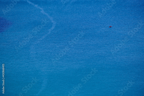 A canoe on the clean blue water of Trebarwith Strand.