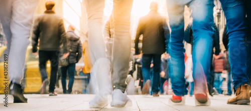 Crowd of people walking in motion in downtown rush hour