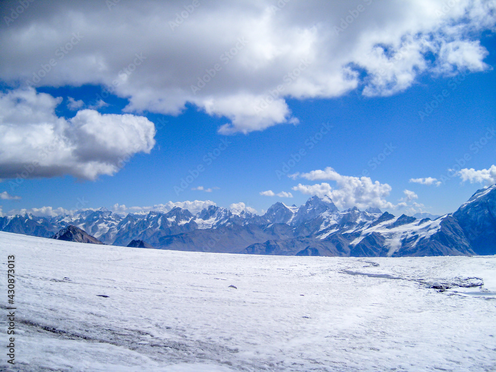 Panorama of snowy mountains with clouds