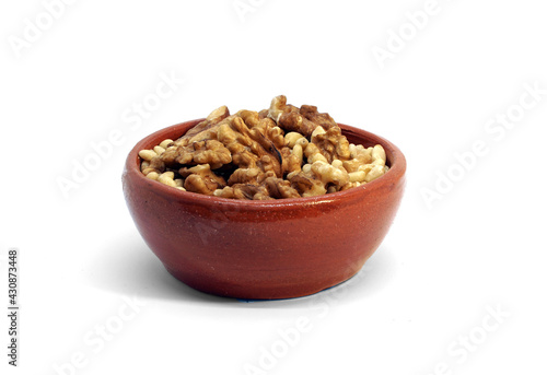 Ceramic, glazed bowl with walnuts and pine nuts. Isolated on white background.