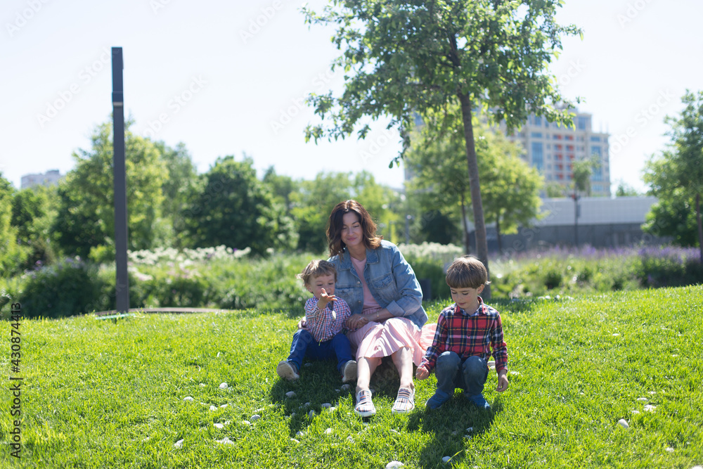 Obraz premium Happy mother with her children spends time in city park