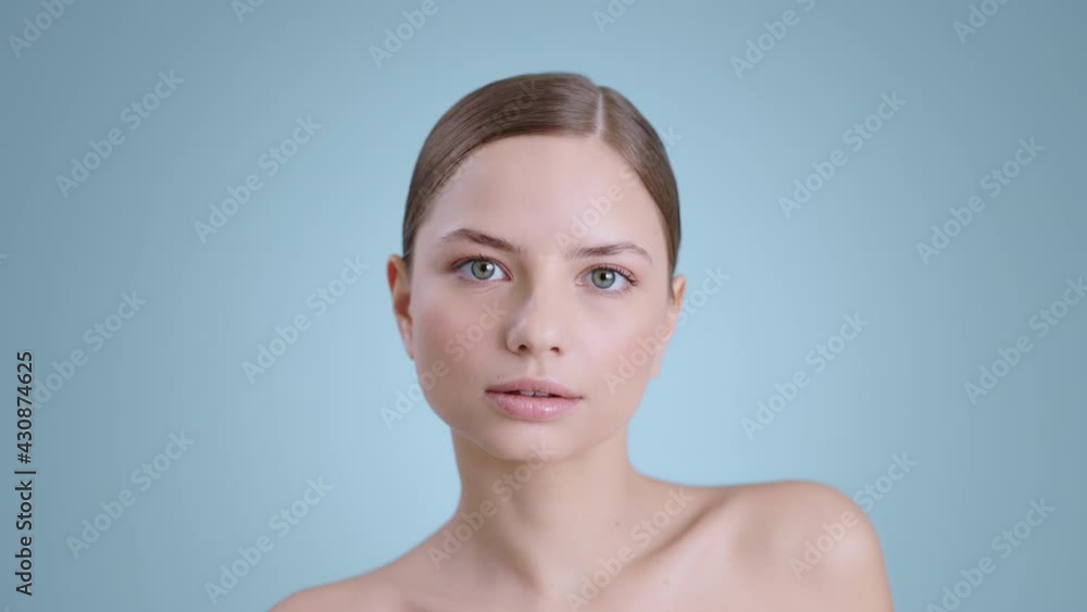 Portrait of pretty millennial woman moving body while looking to camera . Attractive female model with naked shoulders and light nude make up posing at studio background. Portrait of pretty millennial woman moving body while looking to camera . Attractive female model with naked shoulders and light nude make up posing at studio background.