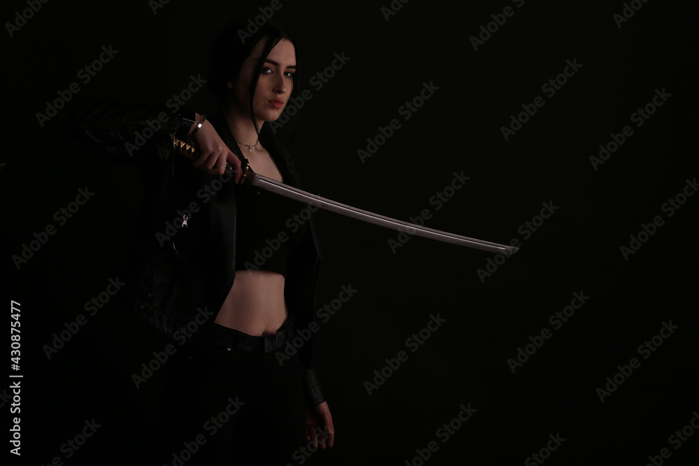 Woman with a katana sword on black background Woman with a katana sword on black background