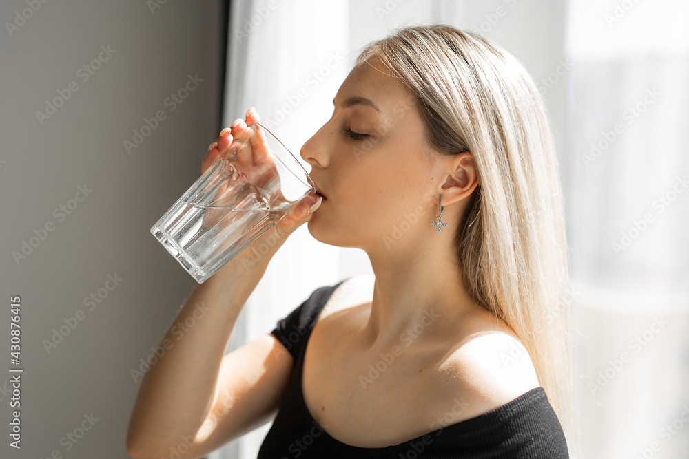 beautiful young woman in sportswear with a glass of water beautiful young woman in sportswear with a glass of water