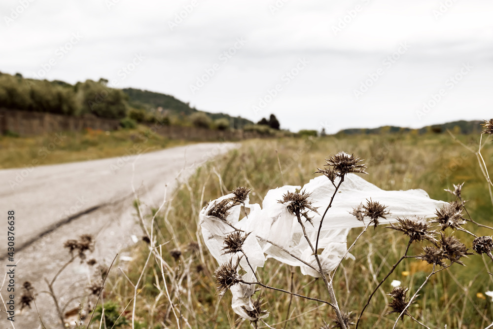 Plastic bag flying in the field and contaminate environment. Environmental problem with waste, trash, garbage. Social issue of pollution of nature. Plastic bag flying in the field and contaminate environment. Environmental problem with waste, trash, garbage. Social issue of pollution of nature.