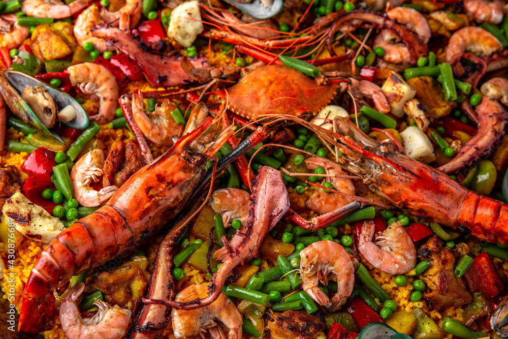 Paella. Spanish dish of rice and seafood, vegetables and chicken. Shrimp, octopus, crab and mussels. Banquet festive dishes. Gourmet restaurant menu. White background. Pattern