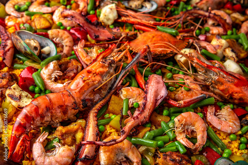 Paella. Spanish dish of rice and seafood, vegetables and chicken. Shrimp, octopus, crab and mussels. Banquet festive dishes. Gourmet restaurant menu. White background. Pattern