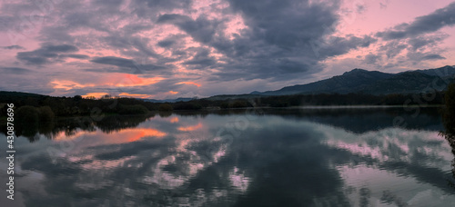 Panoramic view of the Santillana reservoir at sunset. Madrid, Spain. With the mountains of the Sierra de Guadarrama in the background.
