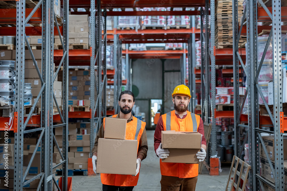 Movers in orange vests standing with boxes Movers in orange vests standing with boxes