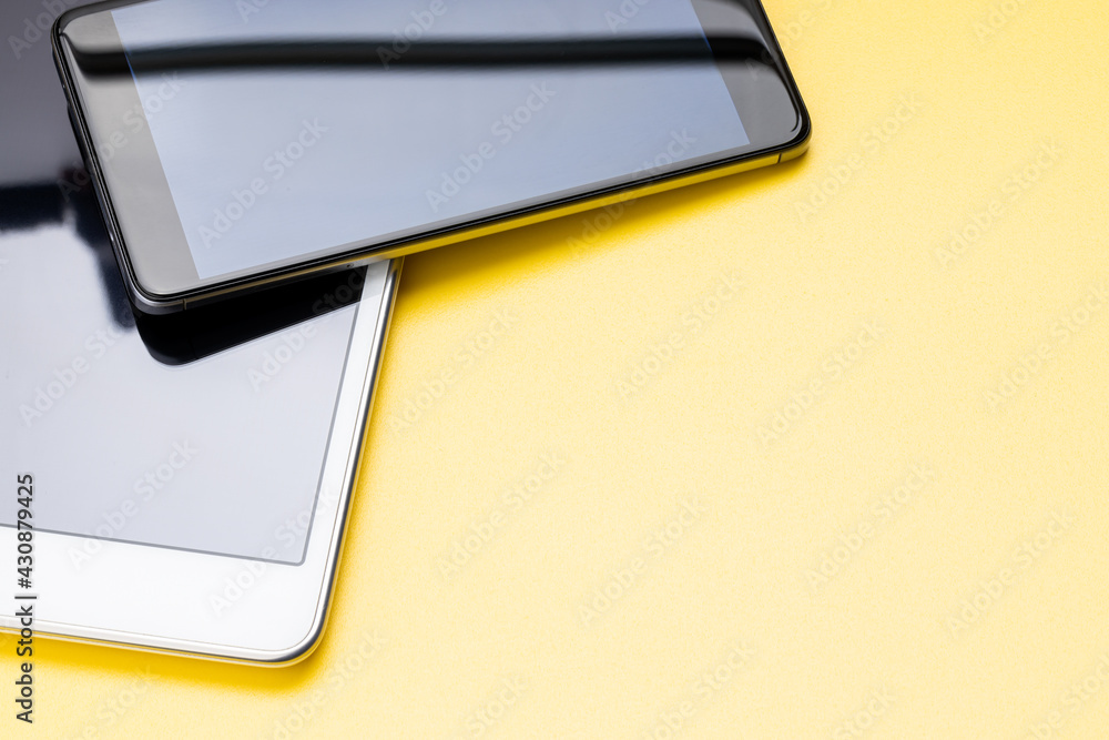 mobile phone and digital tablet on yellow desk with copy space. above view mobile phone and digital tablet on yellow desk with copy space. above view