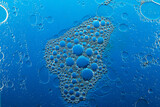A little soapy foam floats on the surface of blue water