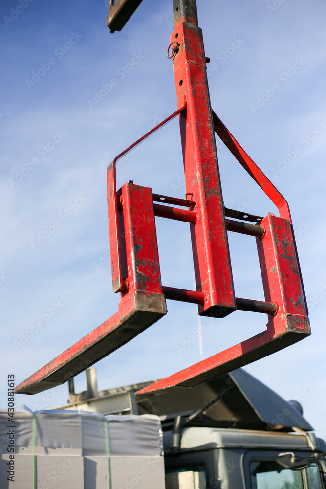 Unloading building blocks from a truck using a crane. Hydraulic manipulator. Unloading building blocks from a truck using a crane. Hydraulic manipulator.