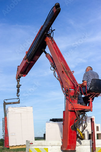 Unloading building blocks from a truck using a crane. Hydraulic manipulator.
