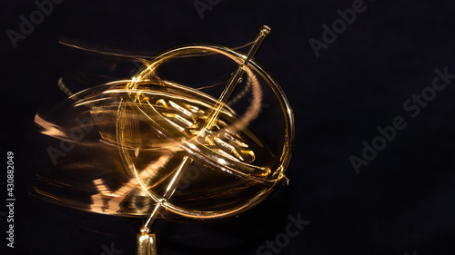 Golden Gyroscope Spinning Wildly on its Base