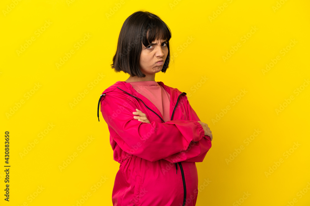 Young pregnant woman over isolated yellow background with unhappy expression Young pregnant woman over isolated yellow background with unhappy expression