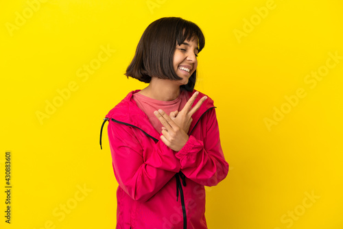 Young pregnant woman over isolated yellow background smiling and showing victory sign © luismolinero