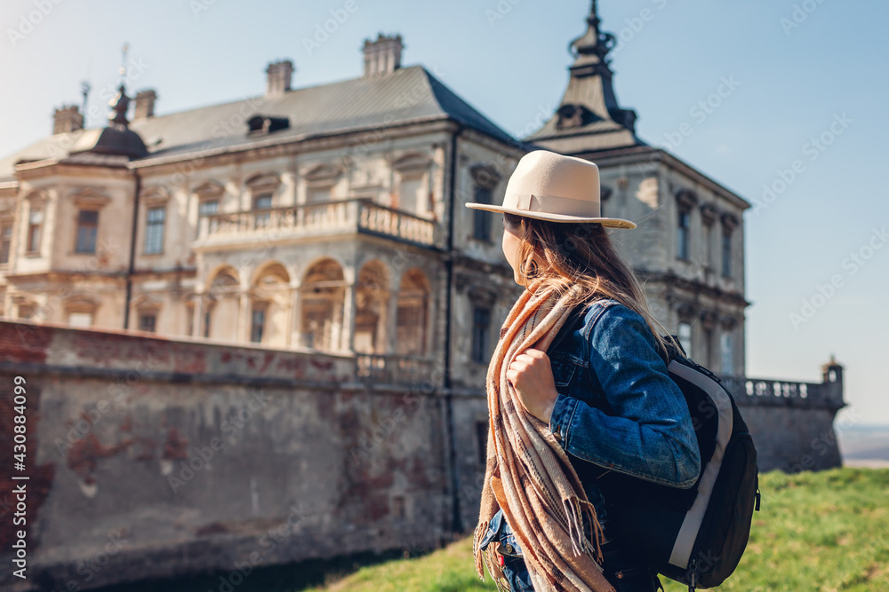 Tourist woman enjoys view of castle in Pidhirtsi. Travel to historic places of interest and landmarks in Western Ukraine