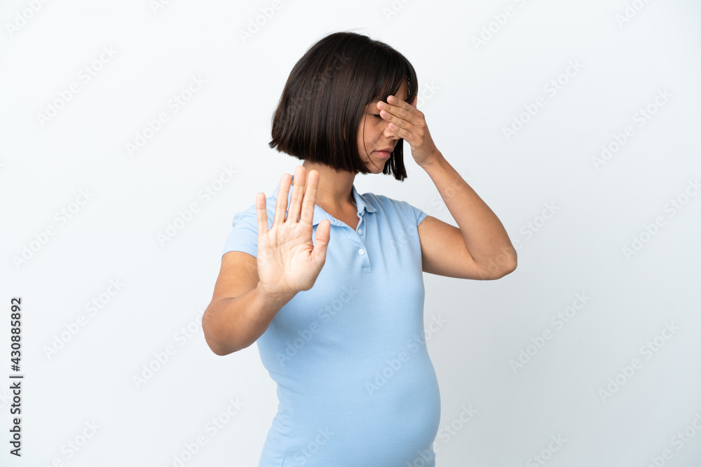 Pregnant woman over isolated white background making stop gesture and covering face Pregnant woman over isolated white background making stop gesture and covering face