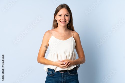 Young Lithuanian woman isolated on blue background laughing