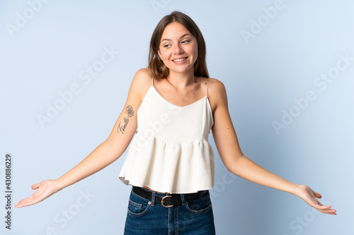 Young Lithuanian woman isolated on blue background happy and smiling