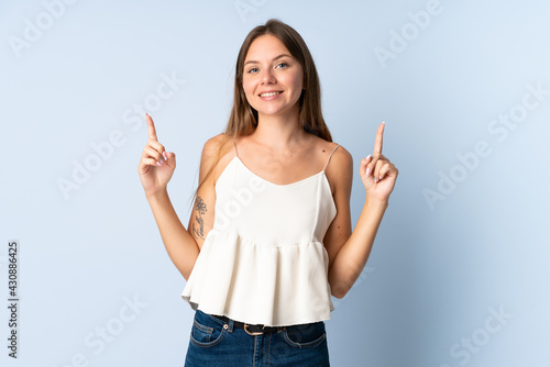 Young Lithuanian woman isolated on blue background pointing up a great idea