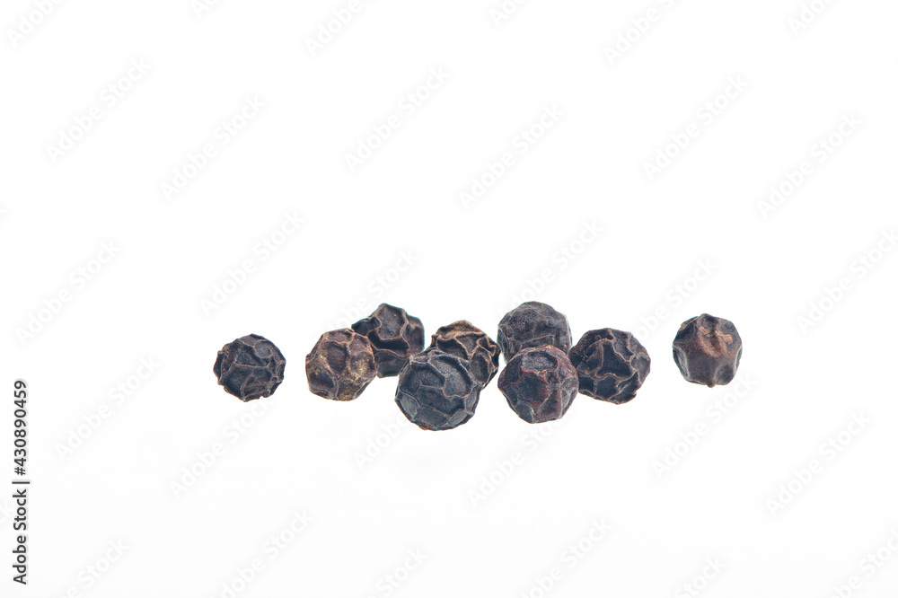 Black pepper grains isolated on white bacground. Heap of dry peppercorn spice. Black pepper seeds close up view. Black pepper grains isolated on white bacground. Heap of dry peppercorn spice. Black pepper seeds close up view.