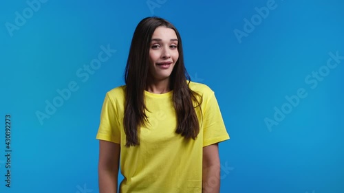 Young woman showing gesture of nonsense, not serious. You're kidding, no way. Hispanic lady reaction to pleasant compliment over blue background.