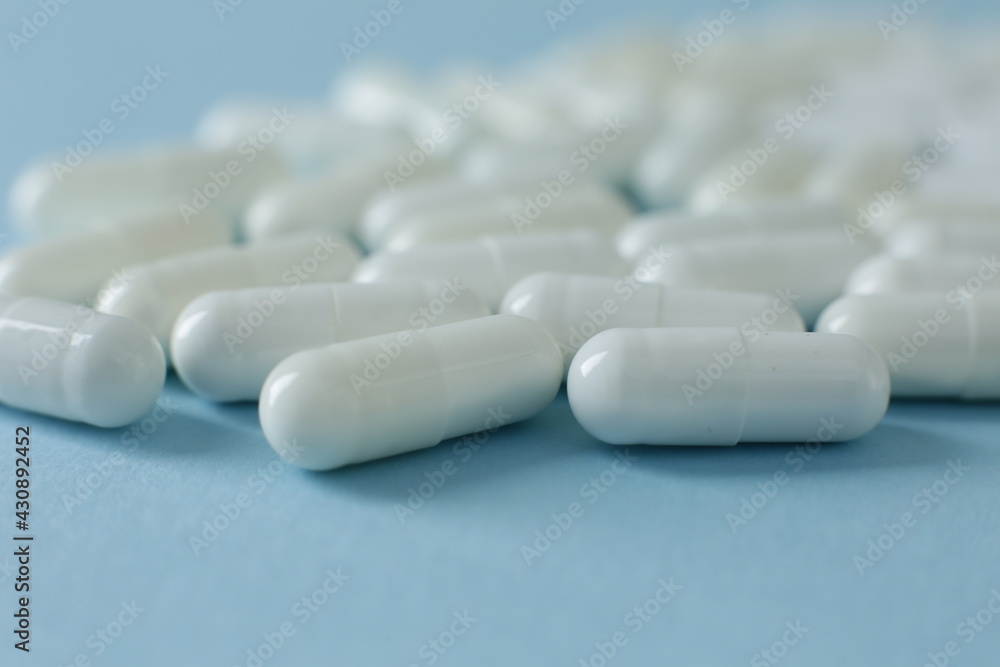 White pills on blue background. Close up White pills on blue background. Close up