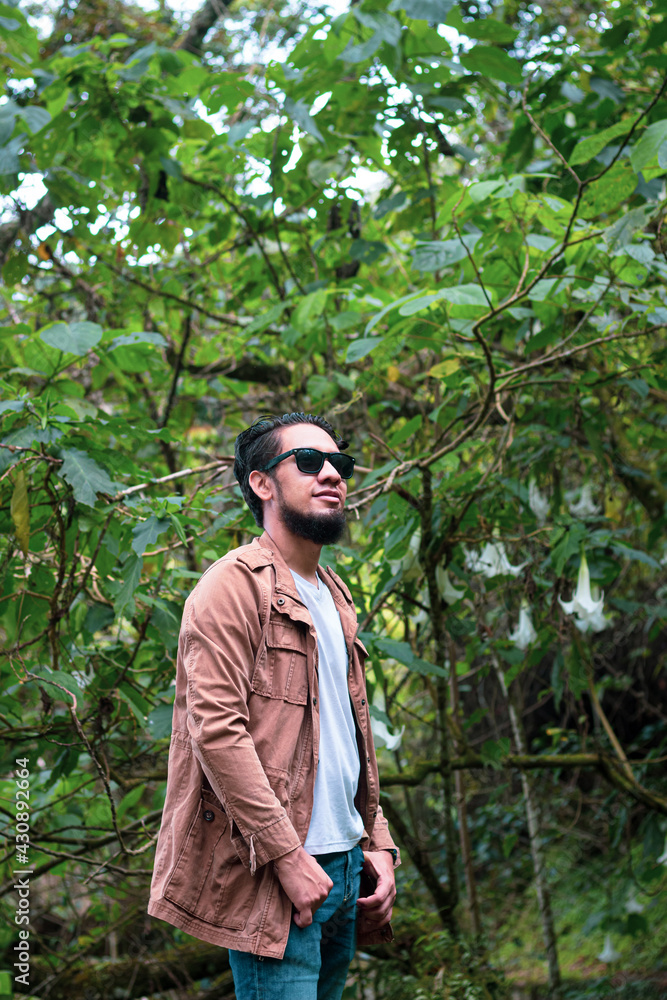 Hombre joven posando con bosque de fondo Hombre joven posando con bosque de fondo